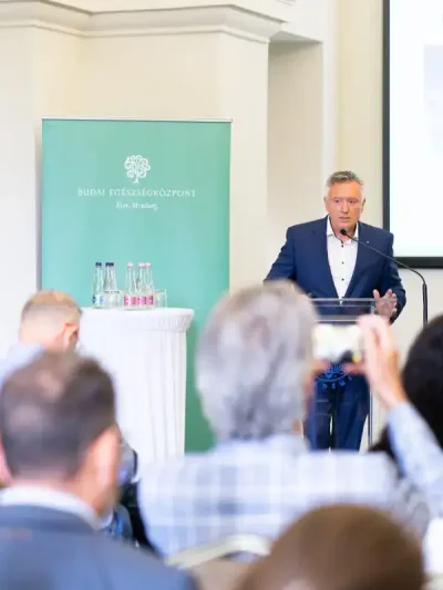 Konferenciafotózás – előadó mikrofonál szakmai prezentáción, üzleti esemény dokumentálása.